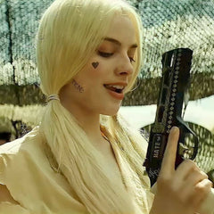 Harley Quinn holding a Chiappa Rhino revolver, showcasing her iconic look with playful expression.